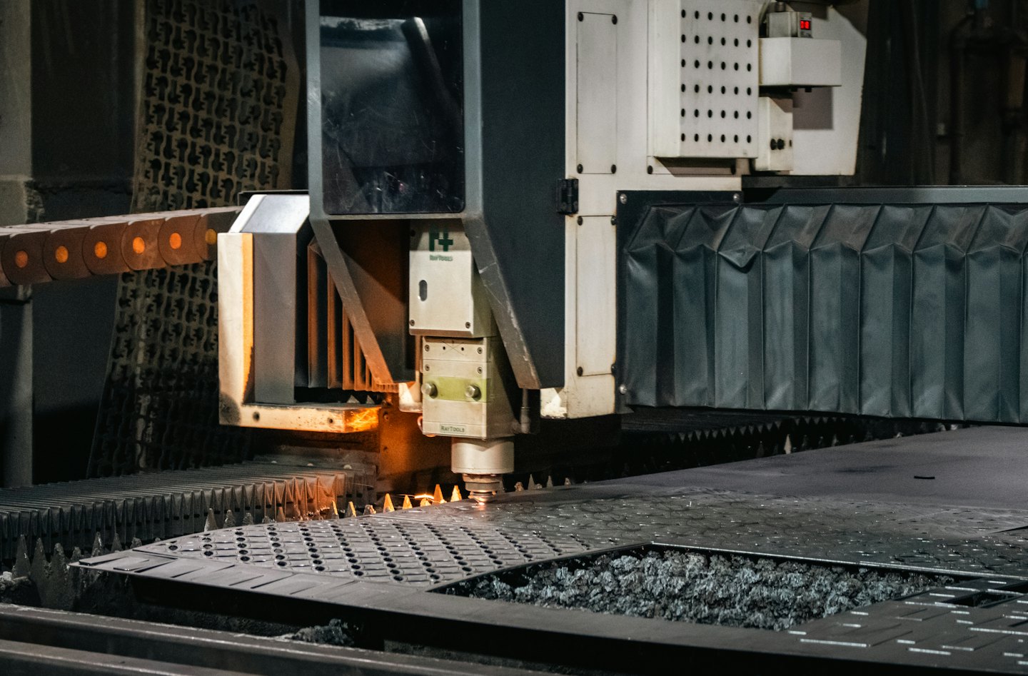 Laser cutting machine precisely cutting metal sheet with bright sparks.